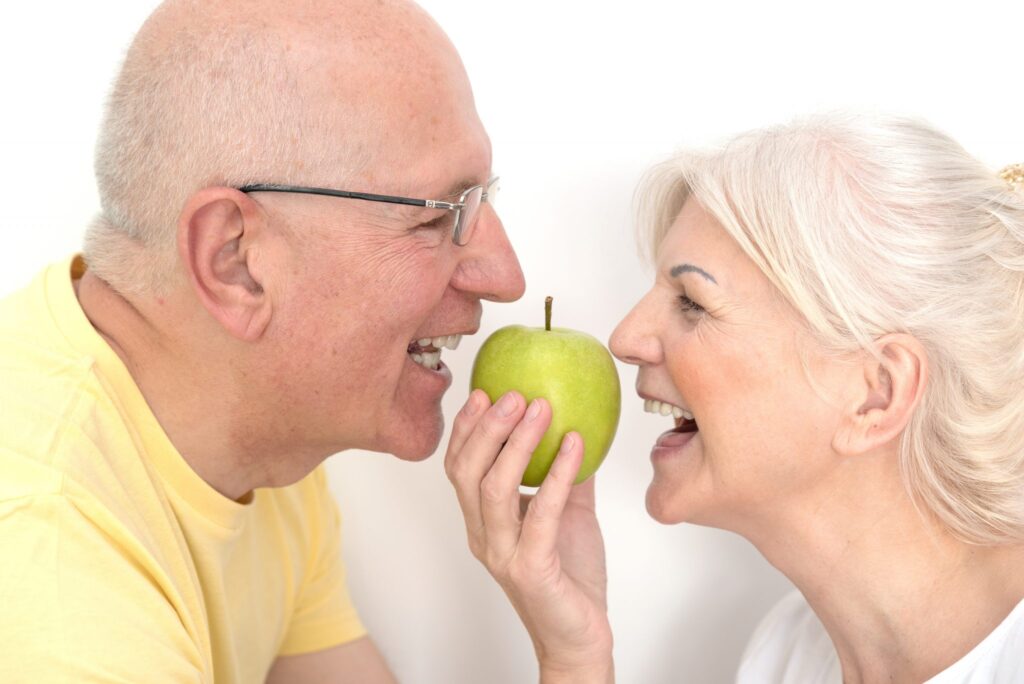 Pareja comiendo una manzana. Salud dental en Barcelona